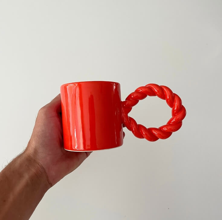 Koffiemok rood met vrolijk handvat in hand