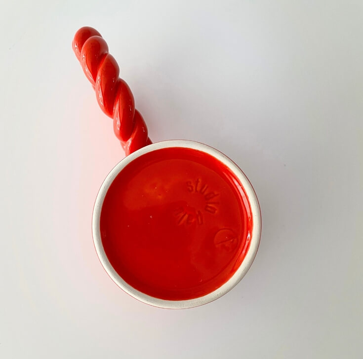 Koffiemok rood met vrolijk handvat onderkant