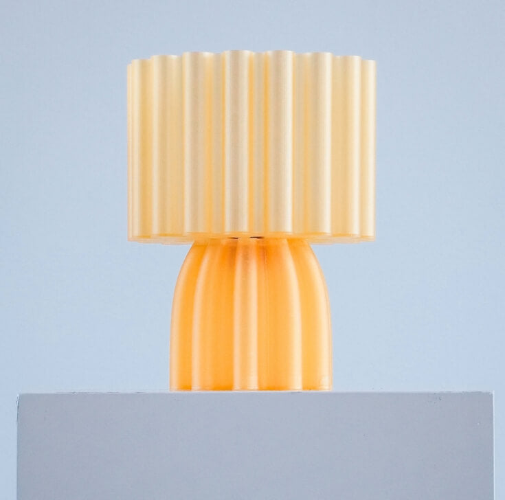 Gele 3d geprinte lamp op stenen paal